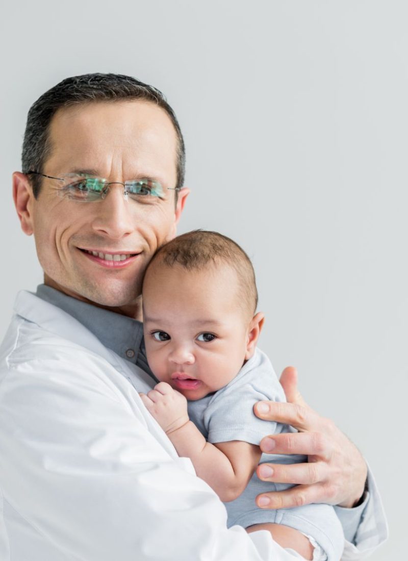 smiling-adult-pediatrician-holding-little-baby-iso-6P3WHJY-1-2-1.jpg